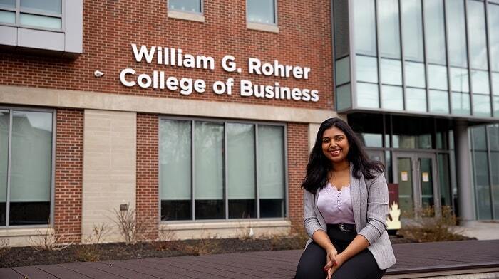 student sitting in front of william g. rohrer college of business